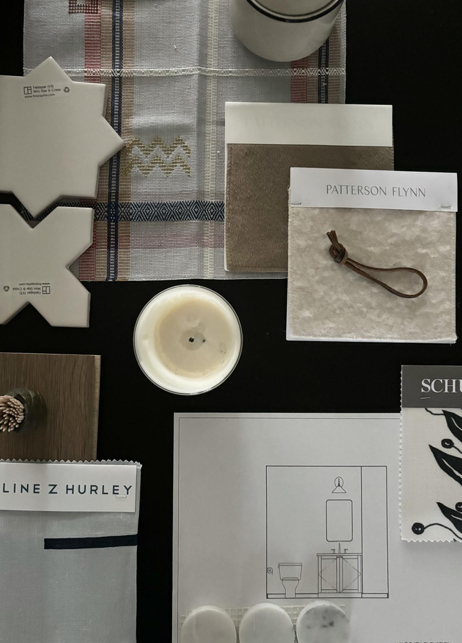 A flat lay of interior design materials and samples including tiles, fabric swatches, a candle, and a bathroom layout dr — Atherton $500k Interior Designer Red-Flags in what Silicon Valley needs to know
