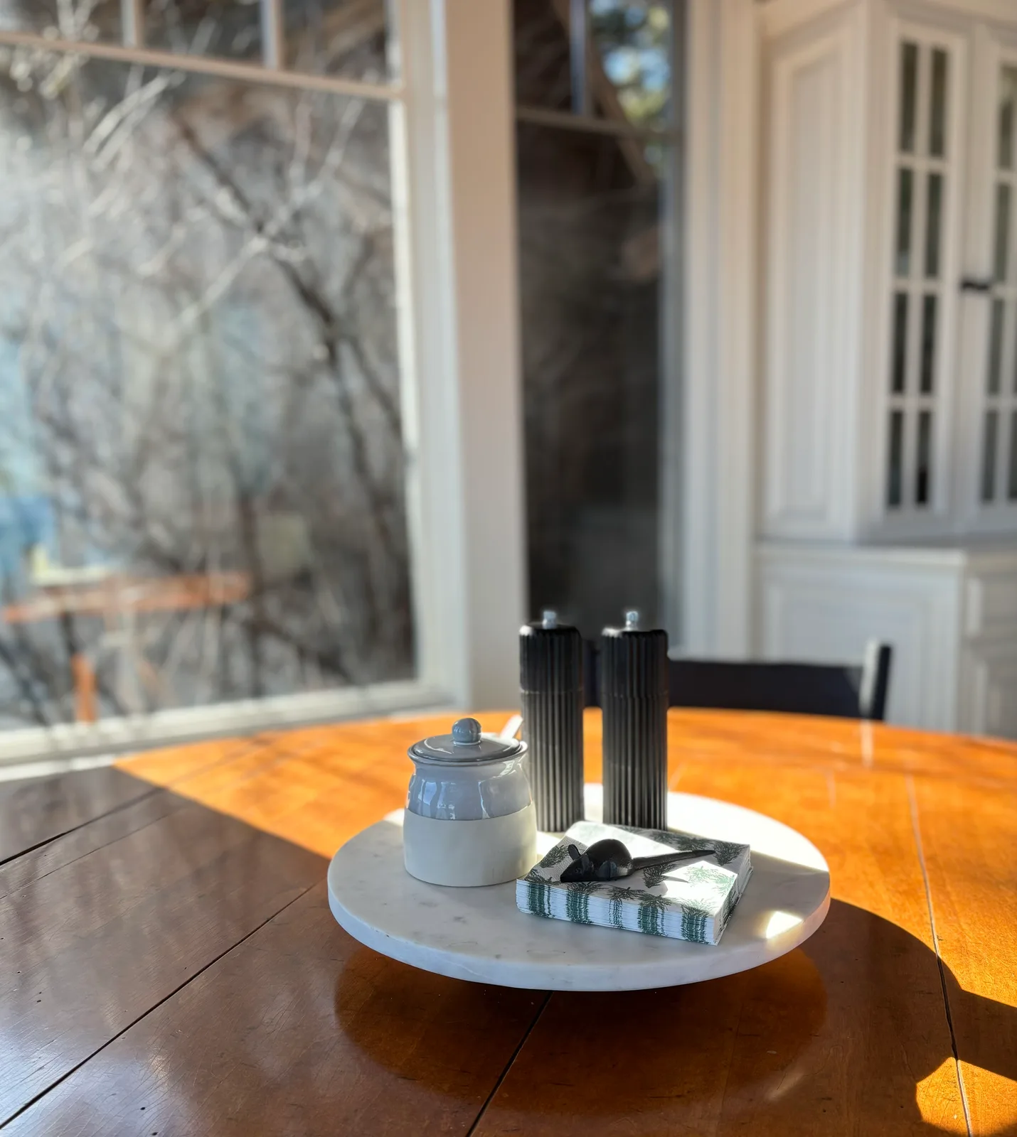 Formal dining table lazy Susan with pewter salt shakers and linen napkins