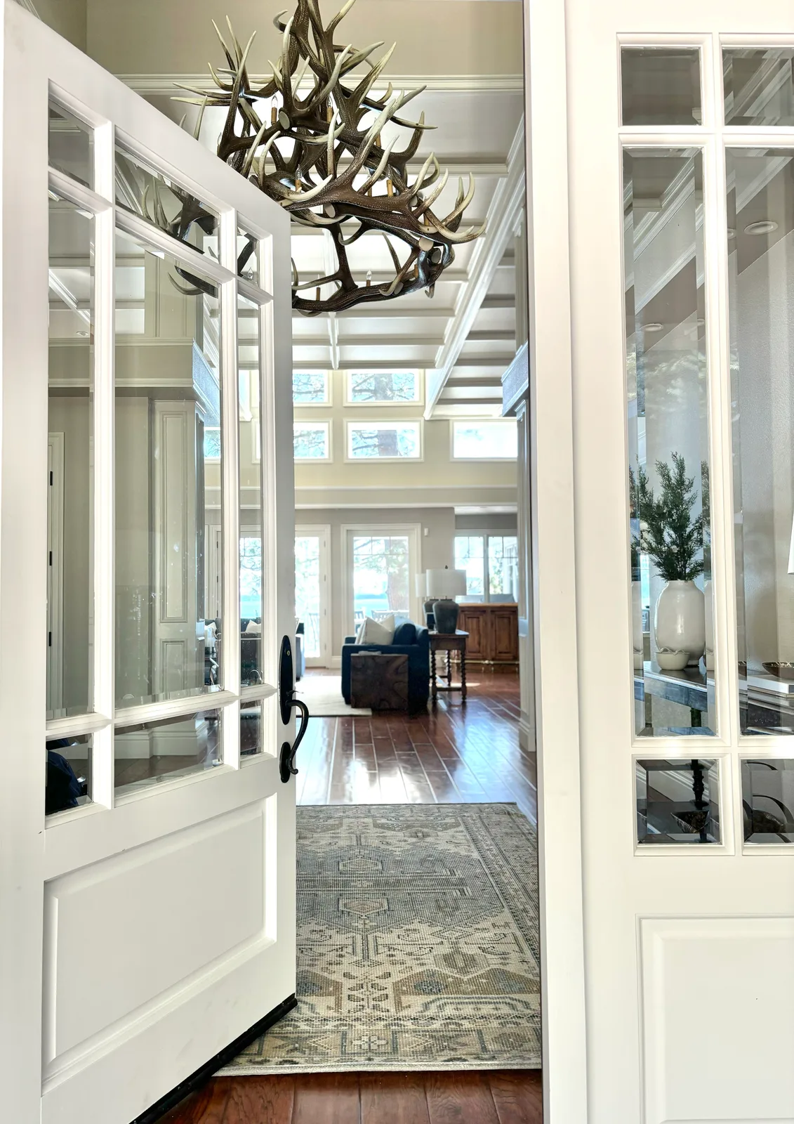 Foyer entry with natural antler chandelier above a Persian runner, looking toward the great room