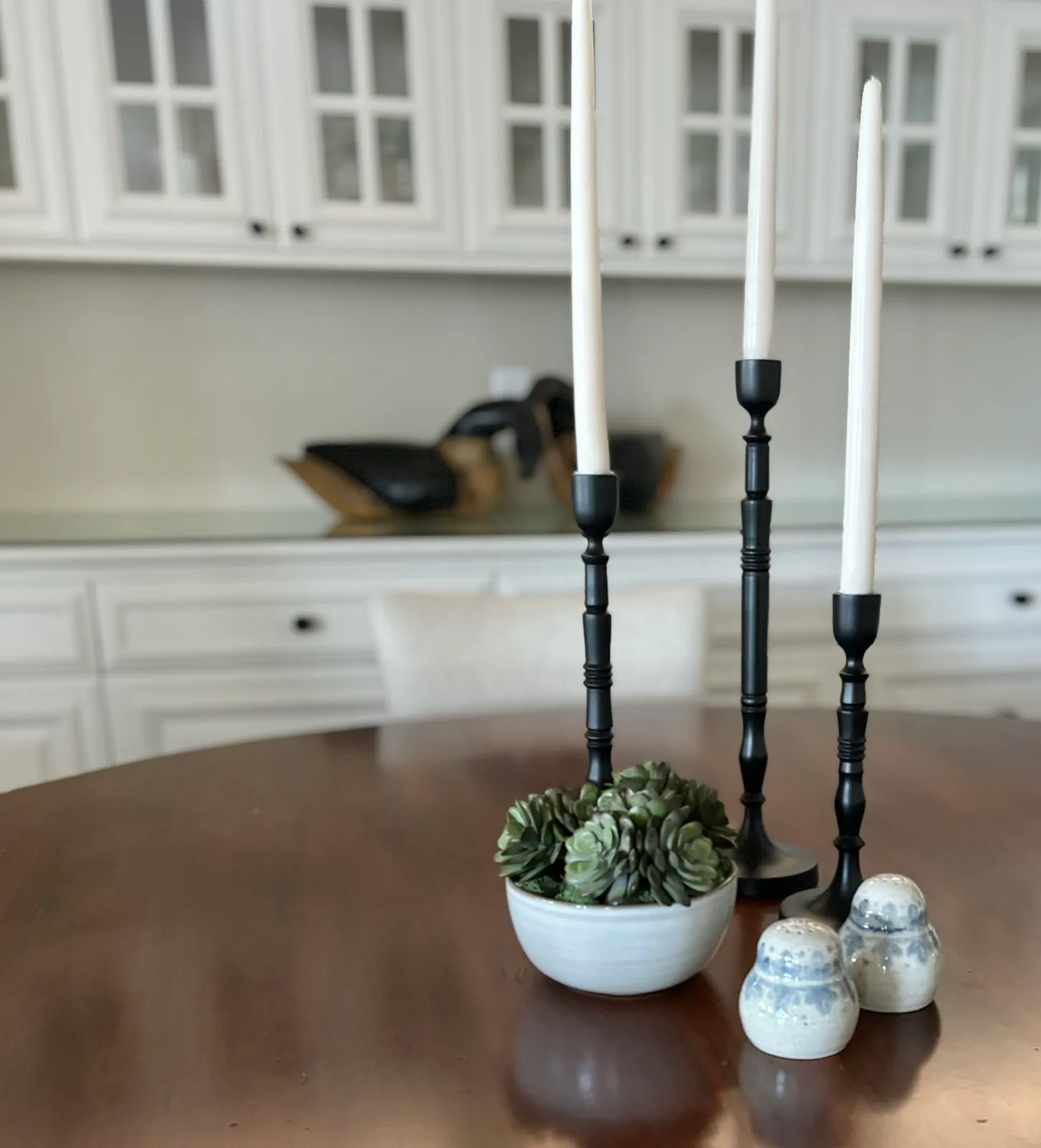 Dining table vignette with tapered black candlesticks and succulent centerpiece
