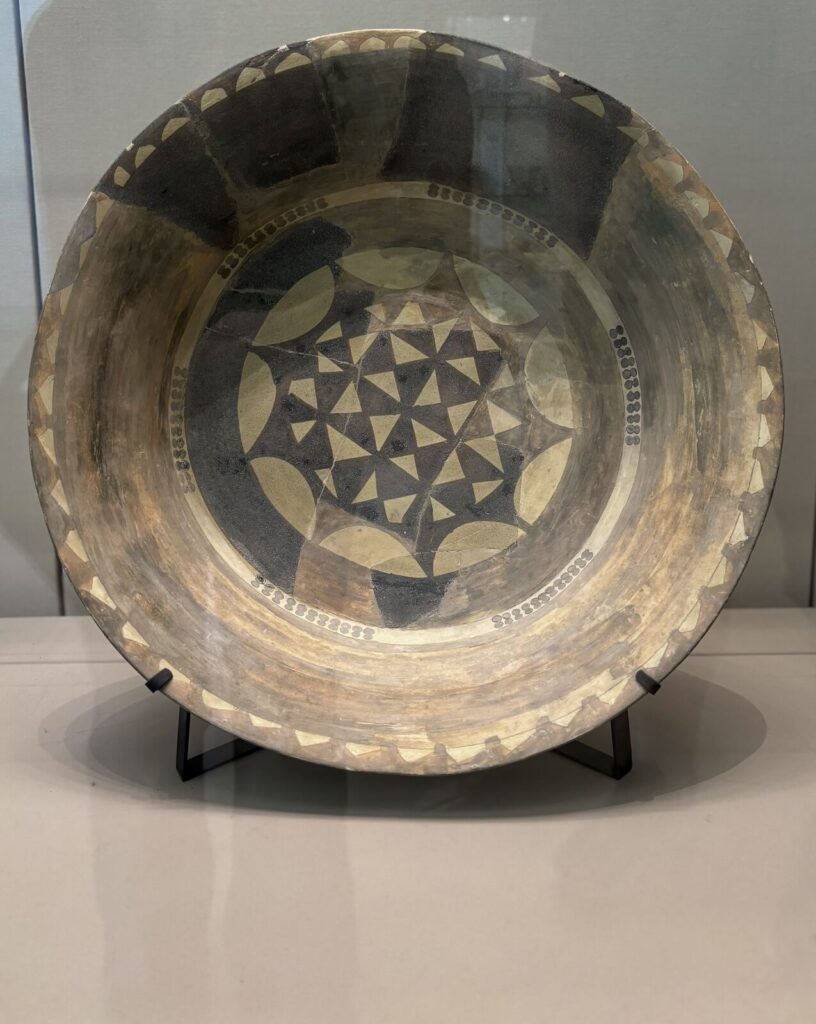 Decorative ceramic bowl with geometric patterns and a natural color palette, showcasing artisanal craftsmanship. The piece ha