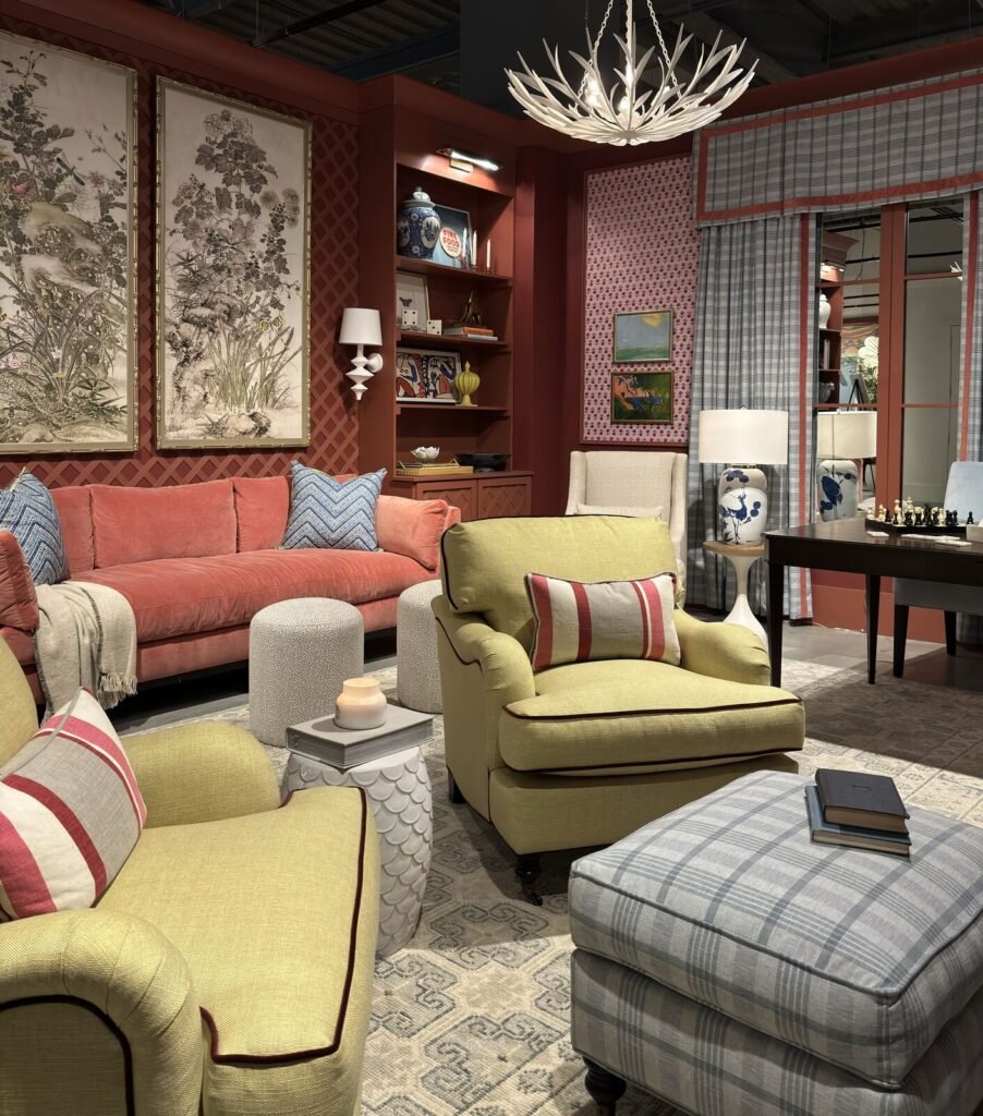 Contemporary living room featuring a mix of soft, pastel colors with a large coral-colored sofa, green armchairs, and pattern