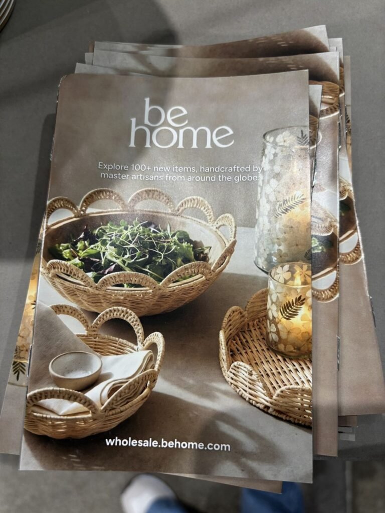 A stack of brochures featuring a home decor collection with a focus on handcrafted items, displayed on a neutral surface. The