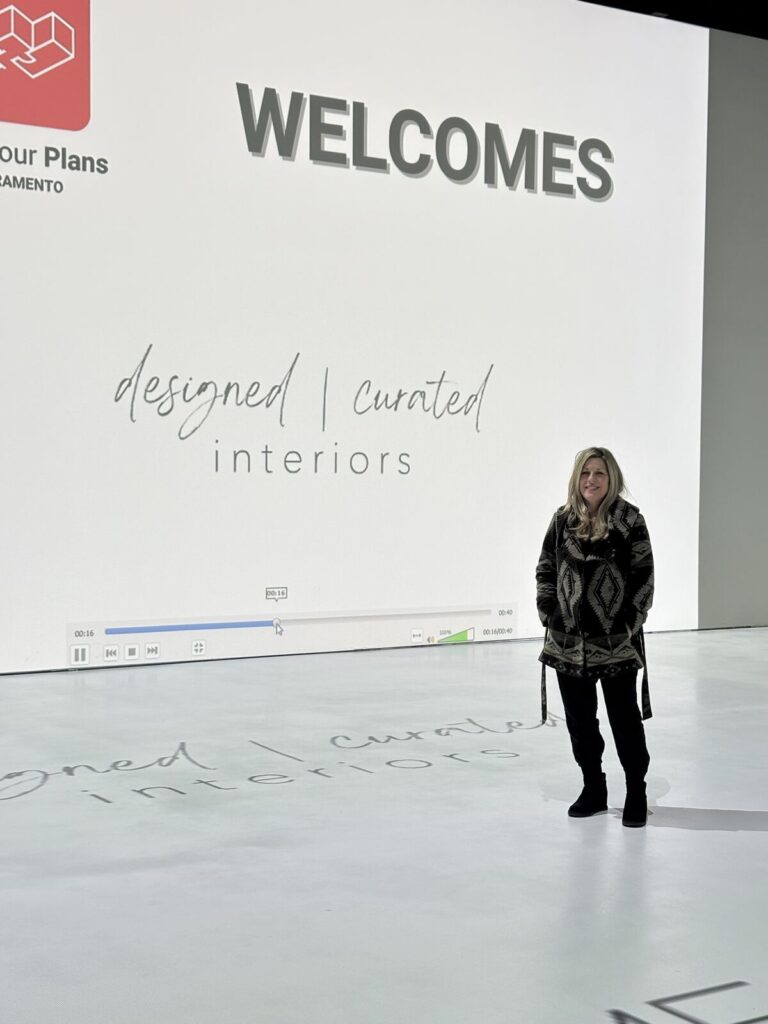 Modern interior space with a large screen displaying a welcome message, featuring minimalist design and polished concrete flo