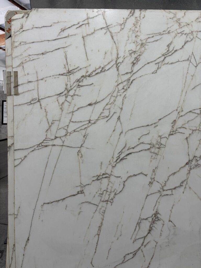 Large marble slab with white background and gray veining, showcasing a polished finish. The material appears to be suitable f