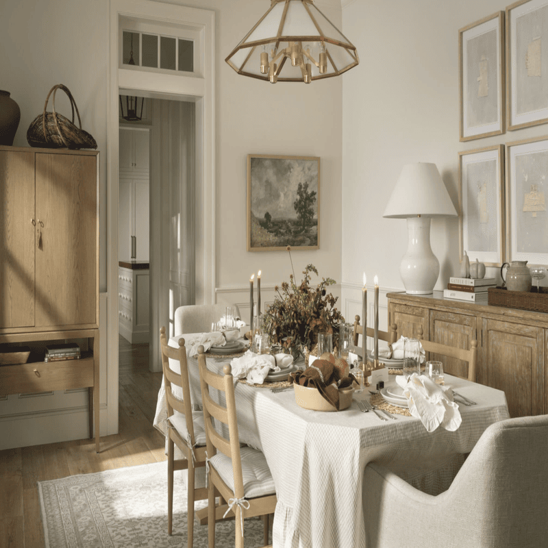 Modern dining room with a light color palette, featuring a wooden dining table surrounded by upholstered chairs and a sideboa