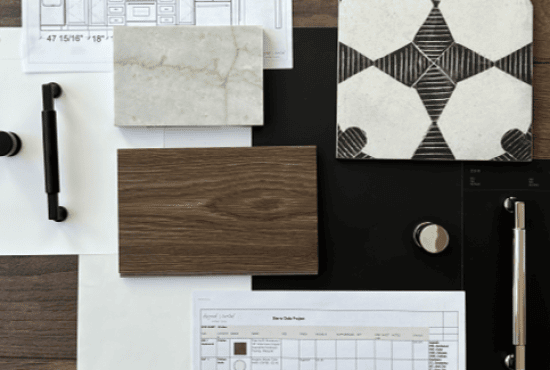 A collection of interior design material samples, including stone, wood, and patterned tiles, arranged on a flat surface with