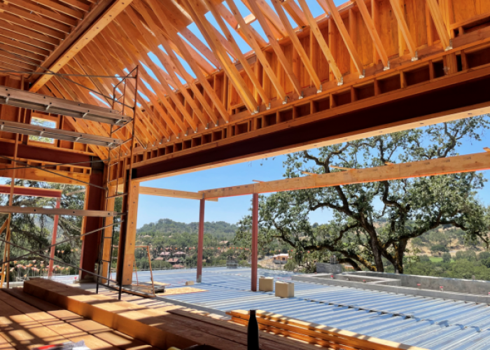 Modern construction interior featuring exposed wooden beams and scaffolding, highlighting an open design and large windows th