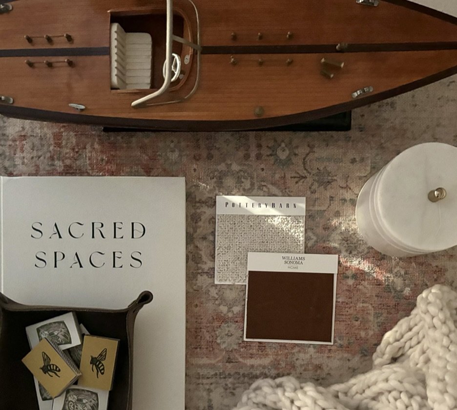 Cozy interior scene featuring a wooden model boat on a vintage-style rug, accompanied by decor items such as a book titled 'S