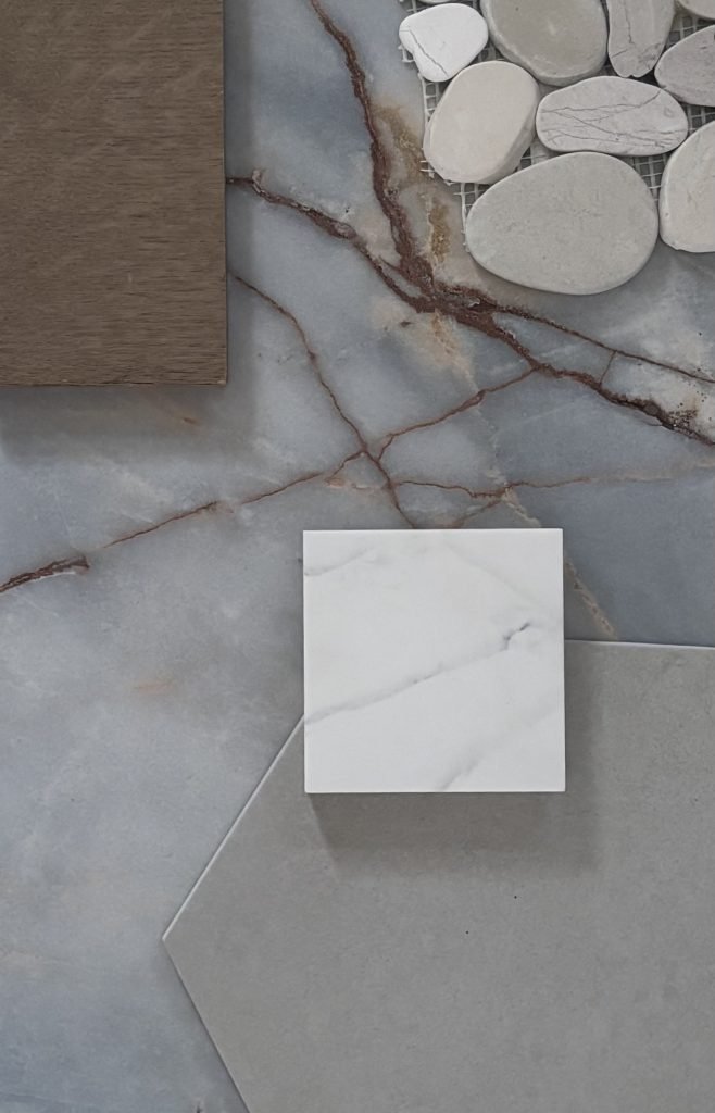 A contemporary interior design setup featuring various stone samples, including marble and polished concrete, laid out on a t