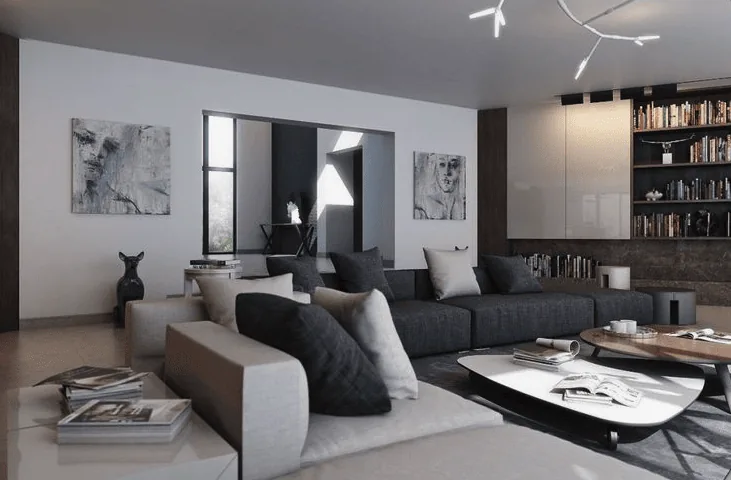 A modern living room with a large sectional sofa, abstract wall art, built-in bookshelves, and a contemporary light