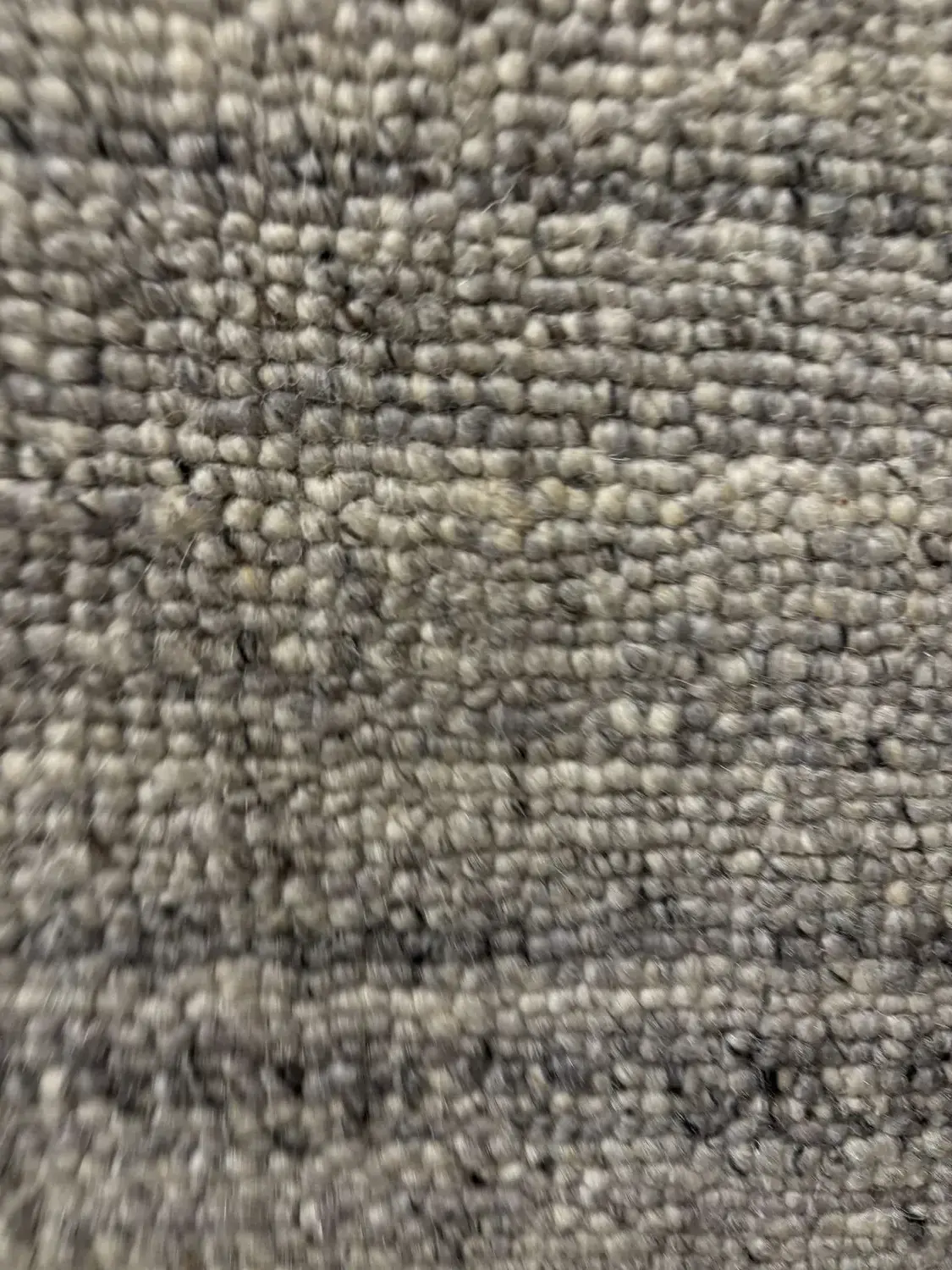 Close-up image of a textured gray carpet or rug surface