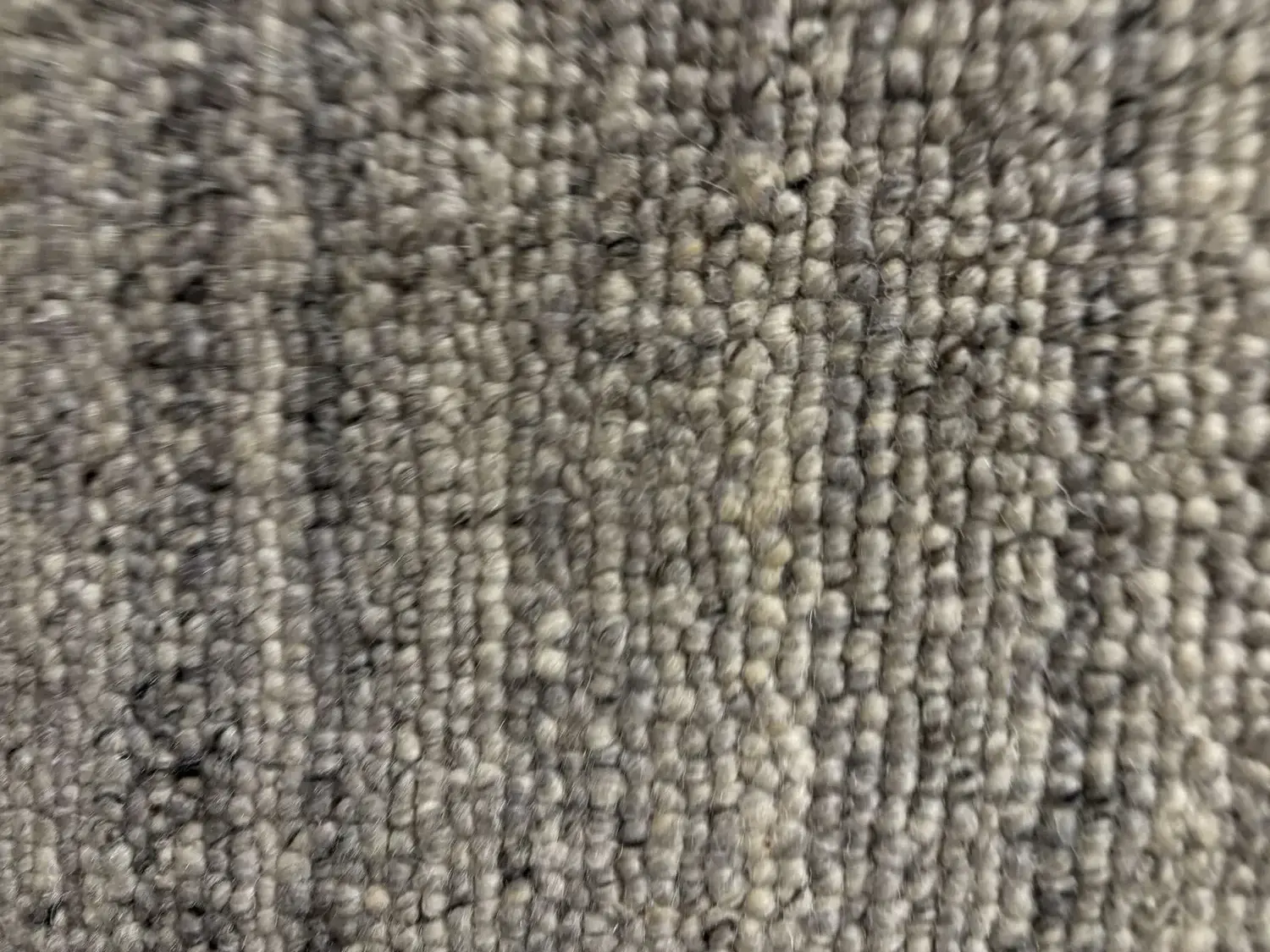 Close-up image of a textured gray carpet or rug surface