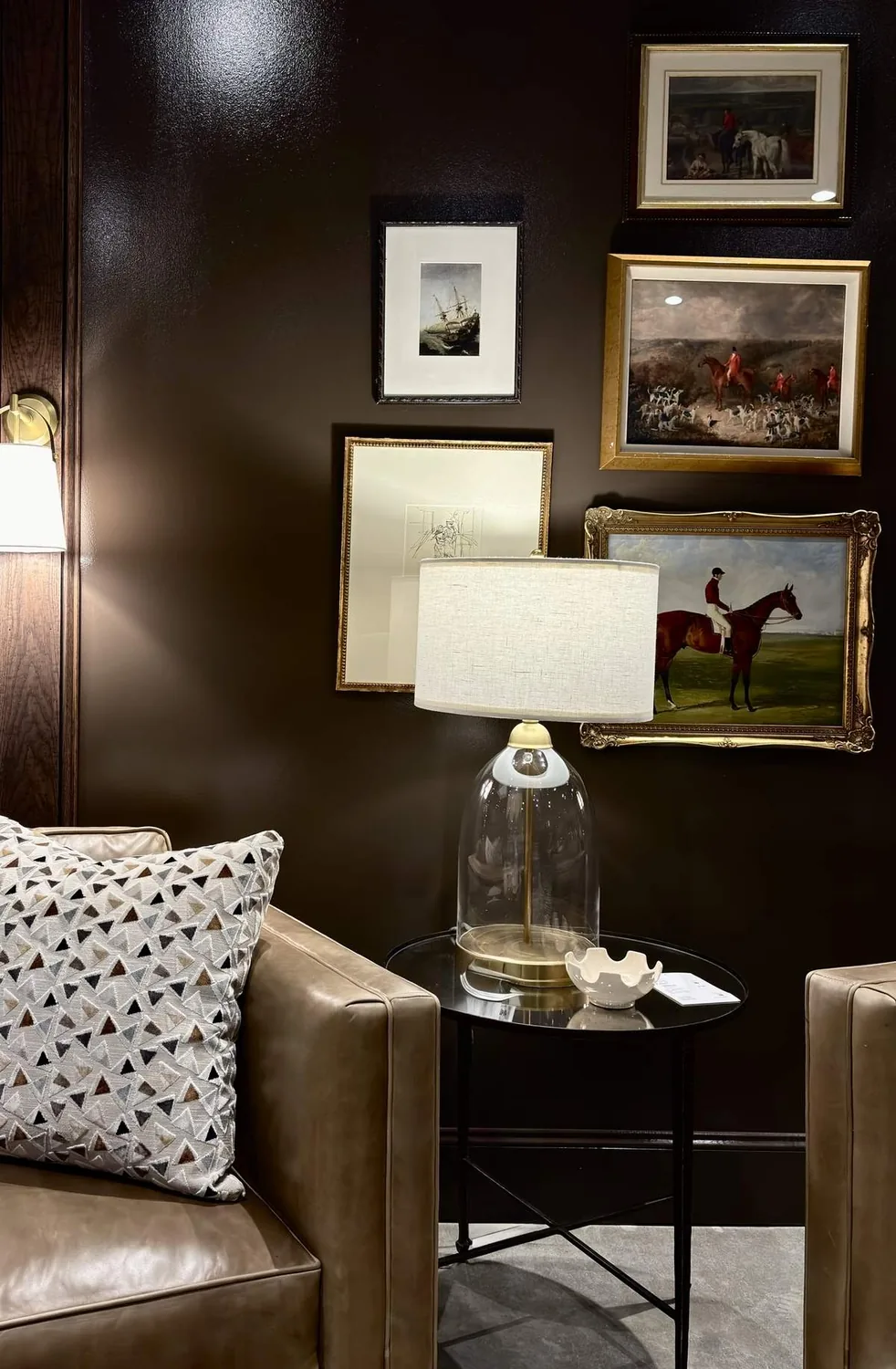 A corner of a room with a framed botanical print on a green wall, a floor lamp, and a partially visible door and window