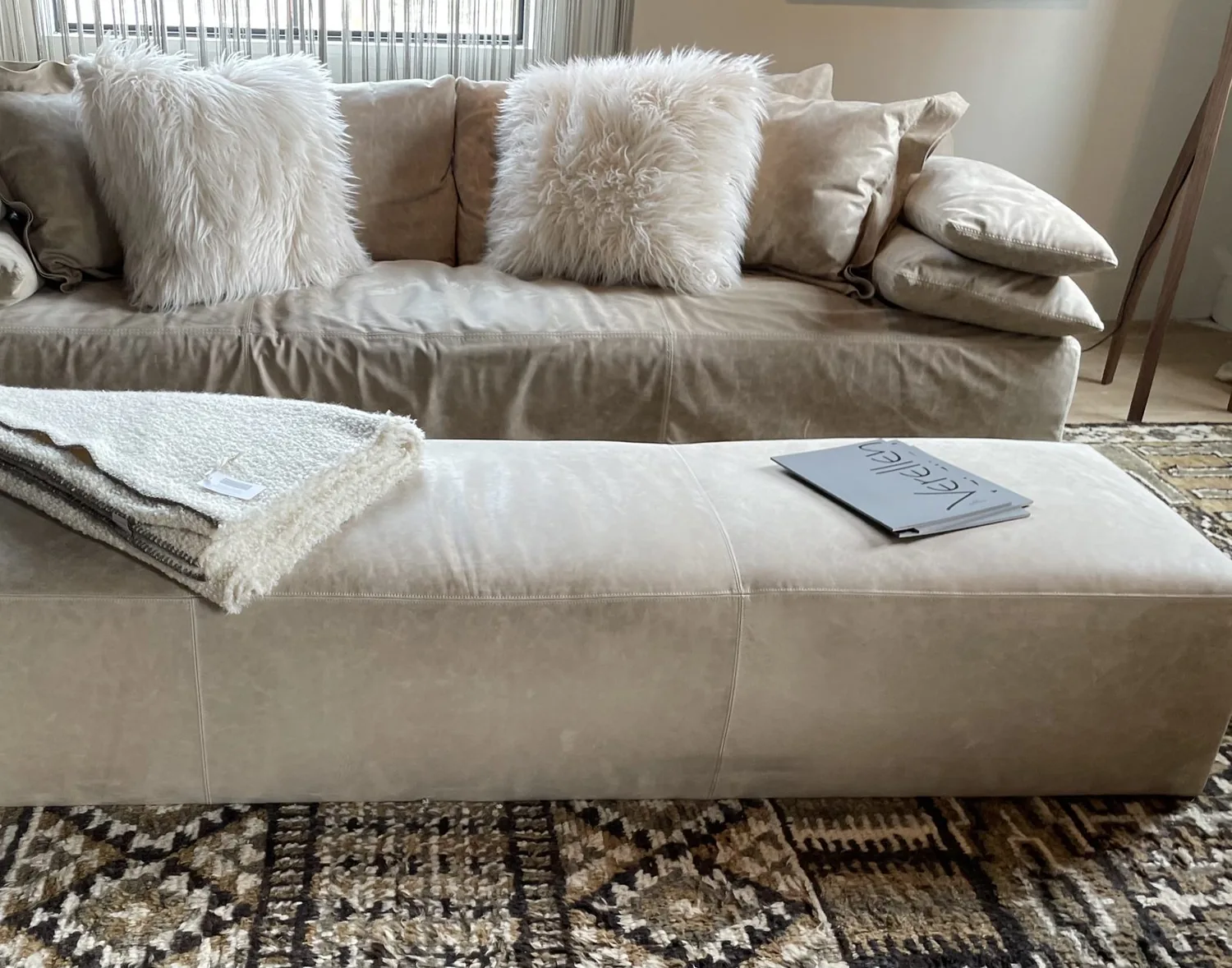 A traditional entryway with a large patterned rug, two upholstered