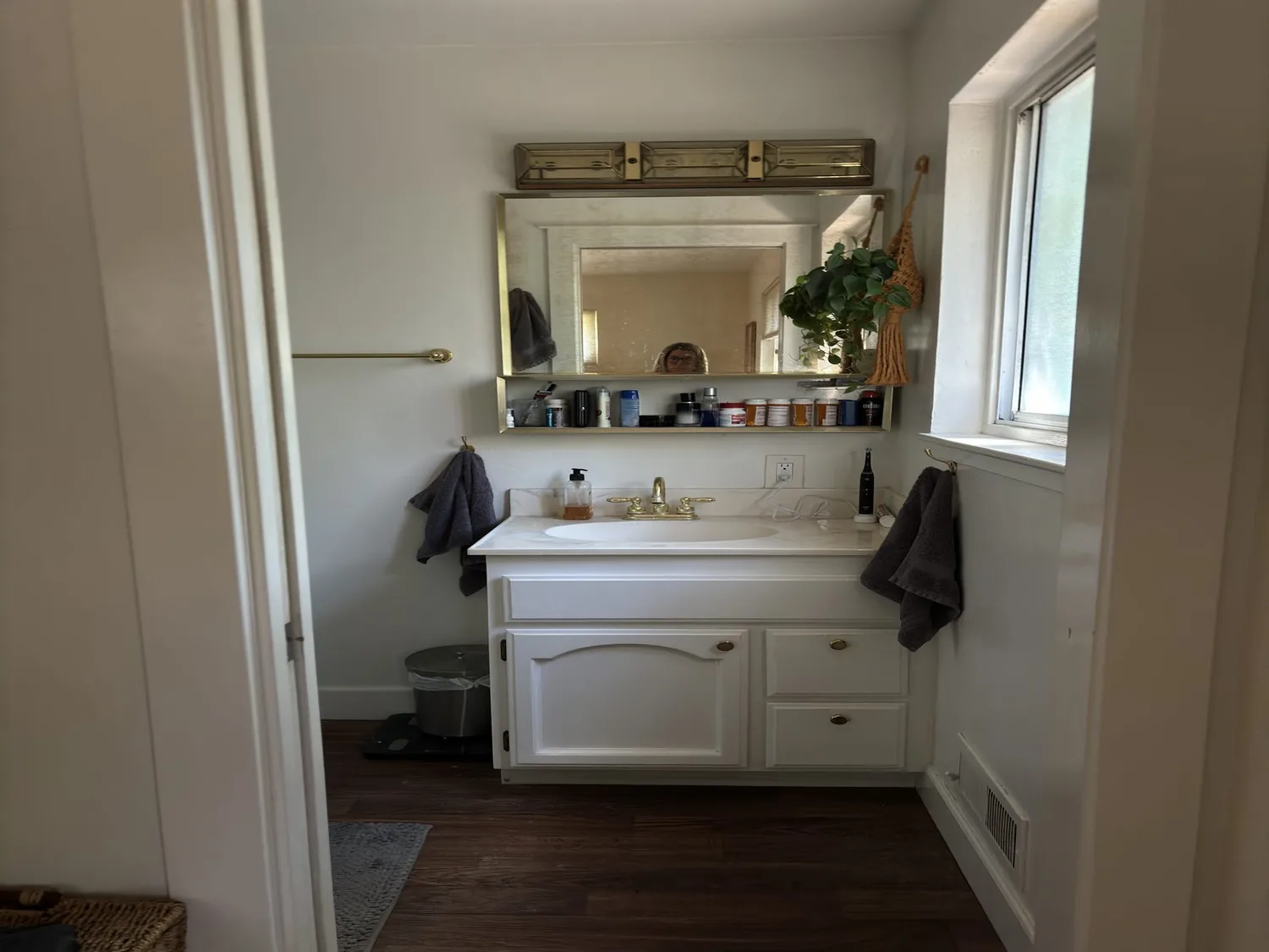 A bathroom with a double sink vanity featuring wooden cabinetry, two rectangular mirrors, white subway tile backsplash
