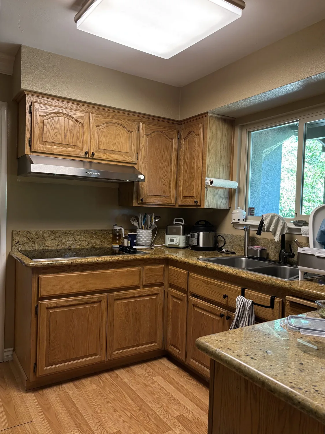 A modern kitchen with white cabinetry, marble countertops and backsplash, wooden cutting boards