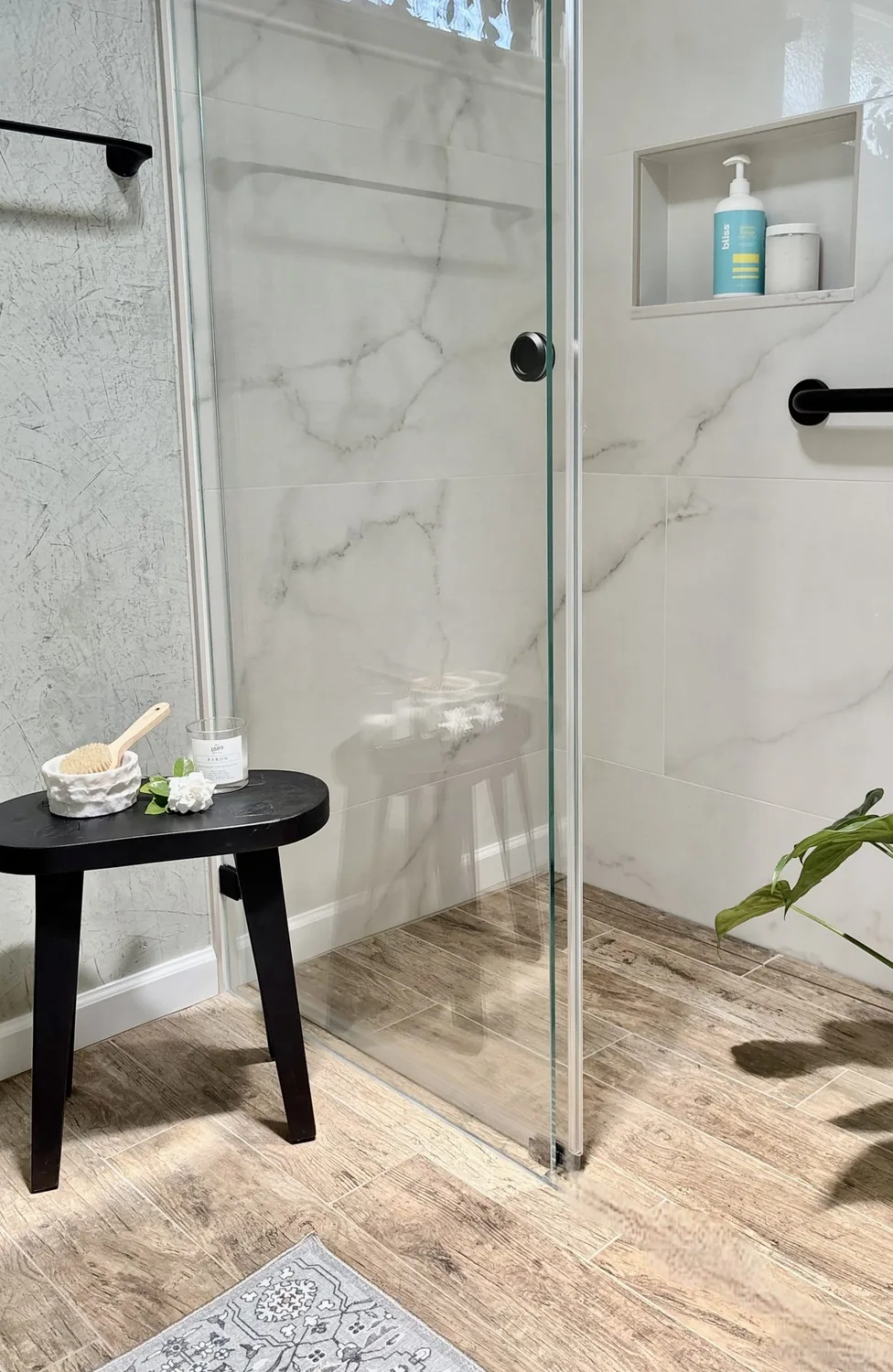 A modern bathroom with a floating wooden vanity, vessel sink, wall-mounted faucet, and a wall-hung toilet next