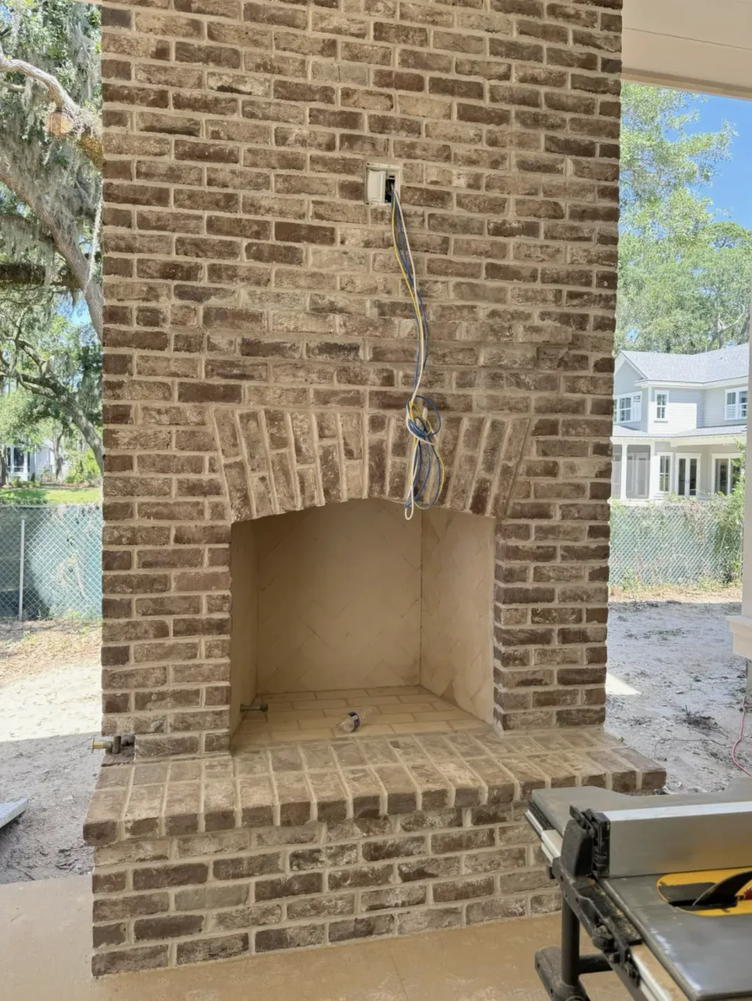 Brick fireplace half-done. Wires exposed
