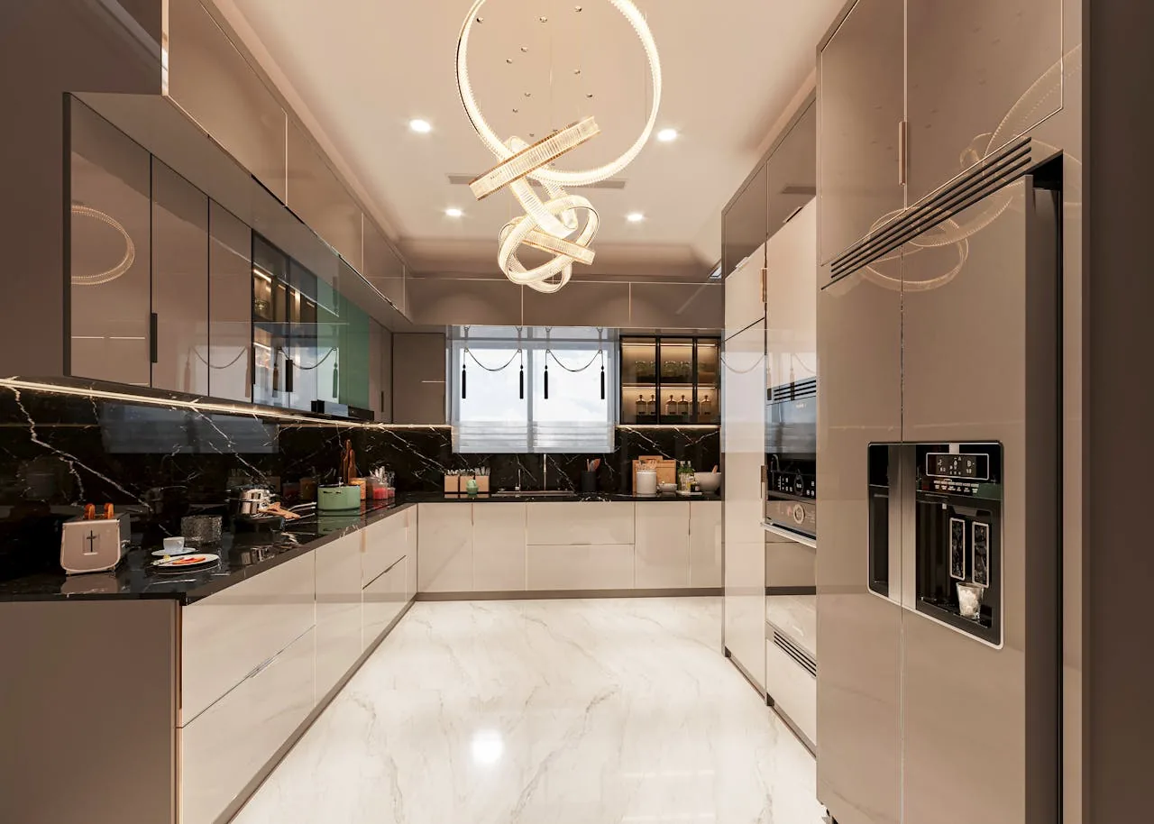 A bright modern kitchen with white cabinetry, a large marble island, stainless steel appliances, and a window overlooking a backyard