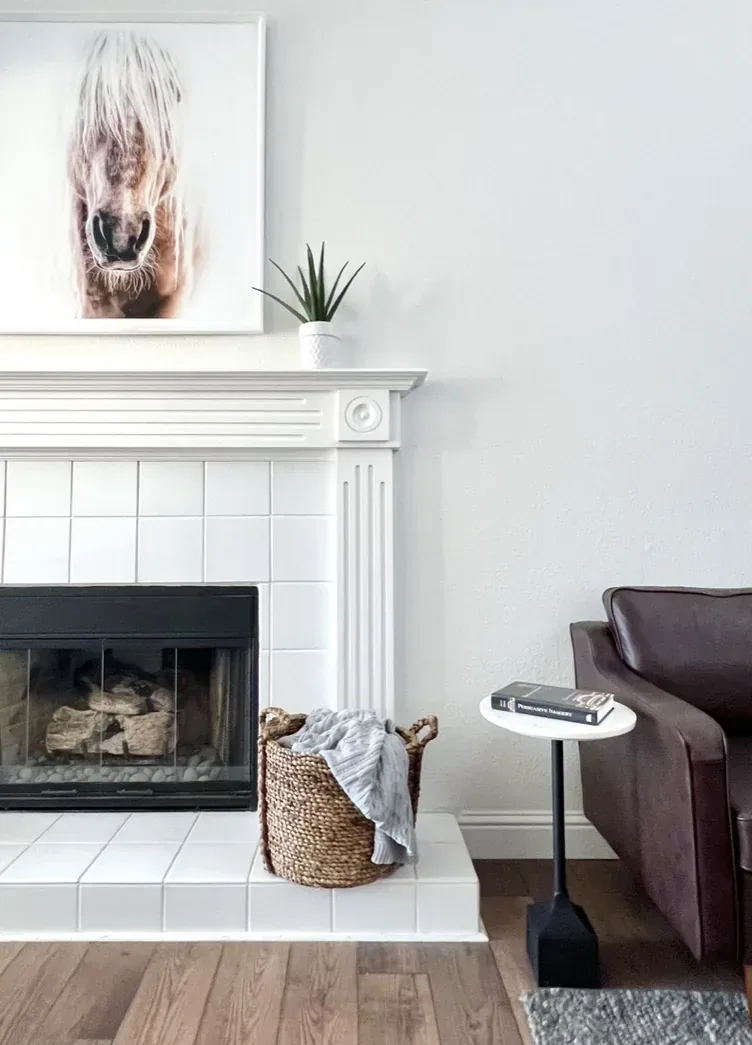 A leather armchair sits near the tiled fireplace in one corner