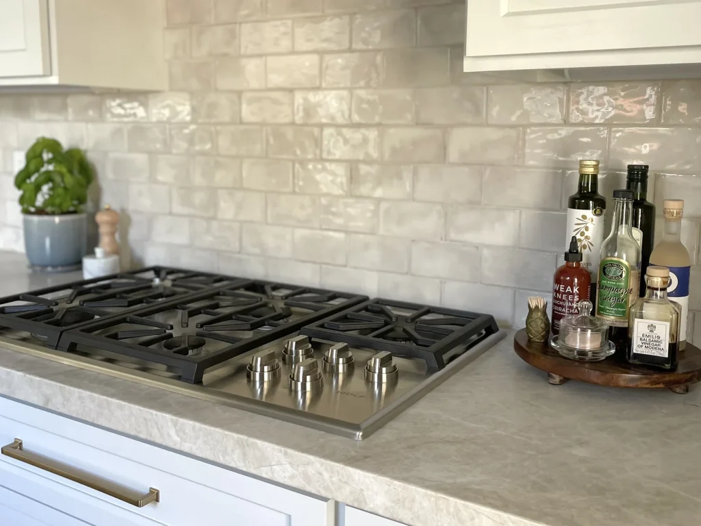 Gas cooktop with handmade tile backsplash and quartzite countertop in a remodeled kitchen, by Designed Curated, Sacramento interior design studio