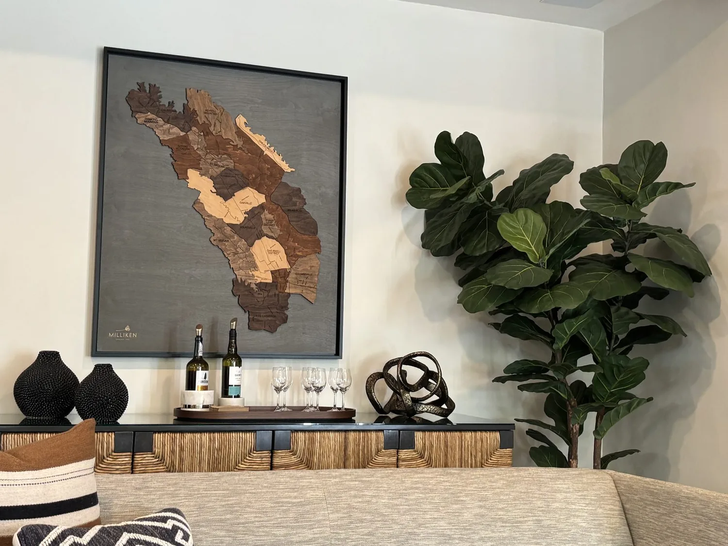 A modern living and dining area with large glass sliding doors opening to a deck with outdoor seating and a river view